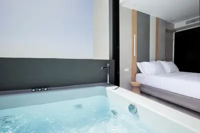a bath tub in a room with a bed at Noemie Luxury Suites in Chania Town