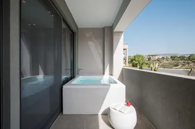a bathroom with a bath tub on a balcony at Noemie Luxury Suites in Chania Town