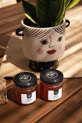 two jars of jam sitting on a table with a vase at Villa Peacock with Spa Facilities in Daratso