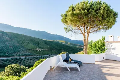 a white chair sitting on a balcony with a tree at Ktima Abella ✩ Organic Garden ✩ Absolute Privacy in Élos