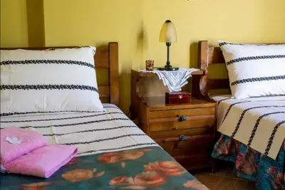 a bedroom with two beds and a night stand with a lamp at Ktima Abella ✩ Organic Garden ✩ Absolute Privacy in Élos