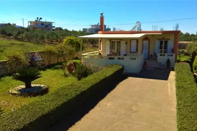 a small house with a green hedge at Pazinos/Neveli Cottage in Galangádhos