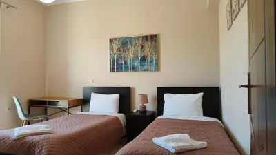 a hotel room with two beds and a chair at Pazinos/Neveli Cottage in Galangádhos