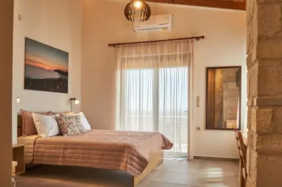 a bedroom with a bed and a large window at Villa Olive Valley in Loutrákion