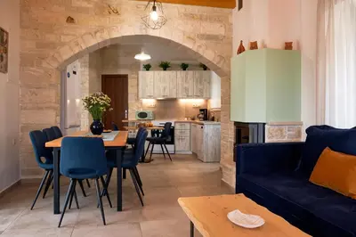 a living room with a blue couch and a table at Villa Olive Valley in Loutrákion