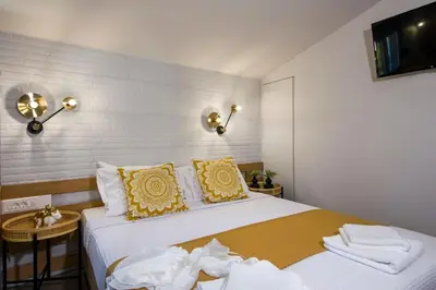 a bedroom with a large bed with yellow and white pillows at Casa Di Camomilla in countryside in Chania Town