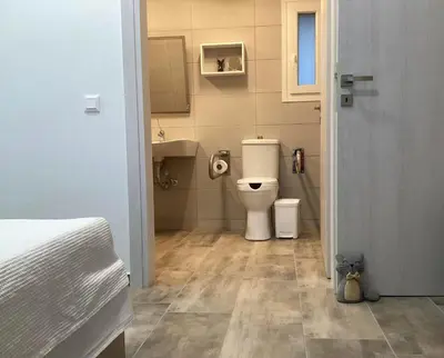 a small bathroom with a toilet and a sink at Landro House in Kissamos