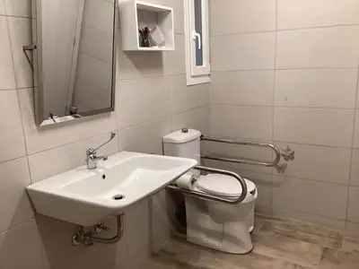 a white bathroom with a sink and a toilet at Landro House in Kissamos