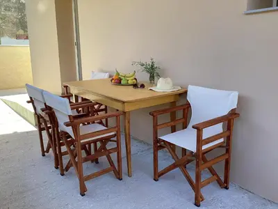 a wooden table with chairs and a bowl of fruit on it at Landro House in Kissamos
