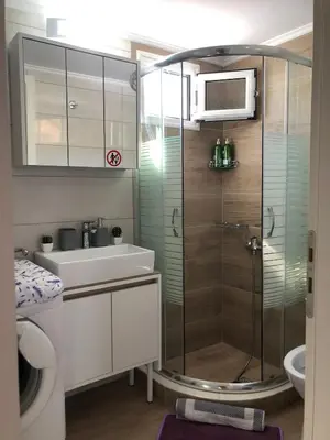 a bathroom with a shower and a sink and a microwave at Summer mood in Chania Town