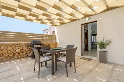 a patio with a table and chairs and a grill at Villa Nektar with private ecologic pool and amazing view! in Kondópoula