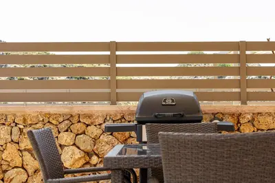 a grill sitting on a table in front of a stone wall at Villa Nektar with private ecologic pool and amazing view! in Kondópoula