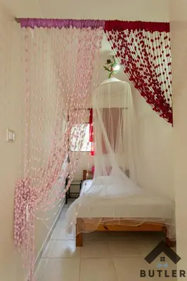a bedroom with a bed with a curtain and a window at Eco Friendly Country Home in Kókkinos Pírgos
