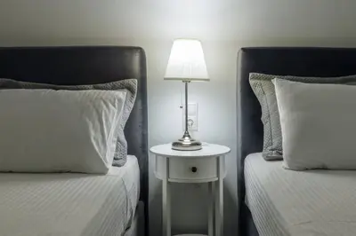 a bedroom with two beds and a table with a lamp at Sfakion 6 apartment in Chania Town