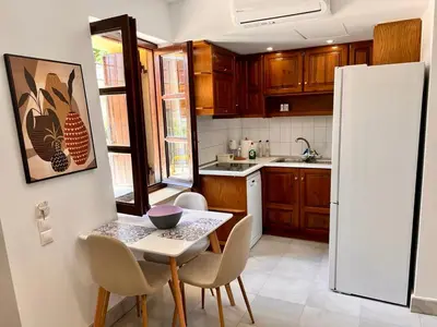 a kitchen with a table and a white refrigerator at Canevaro Twins (North) in Chania Town