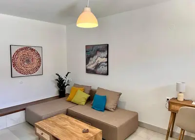a living room with a couch with colorful pillows at Canevaro Twins (North) in Chania Town