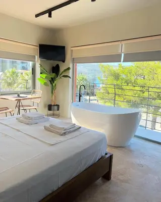 a bedroom with a large tub and a large window at Nidus President in Souda