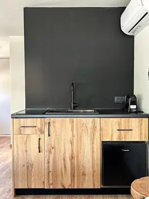 a kitchen with a sink and a black wall at Nidus President in Souda