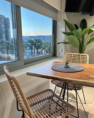a dining room with a table and chairs and a window at Nidus President in Souda