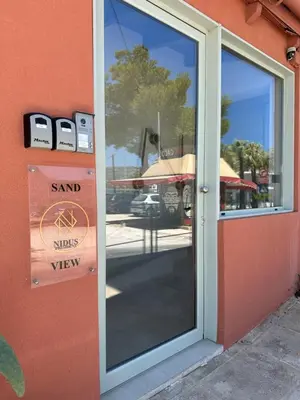 a glass door to a shop with a sign on it at Nidus President in Souda