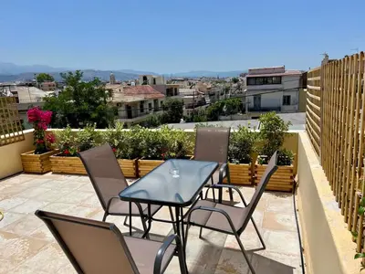a patio with a table and chairs on a balcony at Canevaro Twins (South) in Chania Town