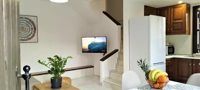 a kitchen and living room with a television on a wall at Canevaro Twins (South) in Chania Town