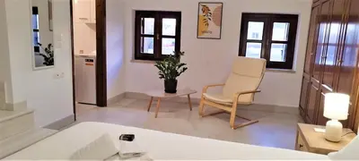 a living room with a chair and a table at Canevaro Twins (South) in Chania Town