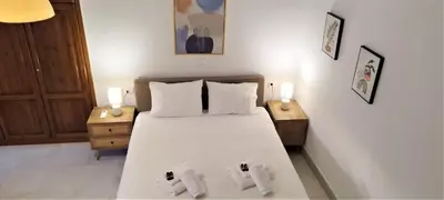 a bedroom with a bed with two towels on it at Canevaro Twins (South) in Chania Town