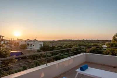 a view of the sunset from the balcony of a house at Efrossini Suites in Kounoupidhianá