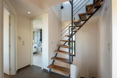a spiral staircase in a home with white walls at Efrossini Suites in Kounoupidhianá
