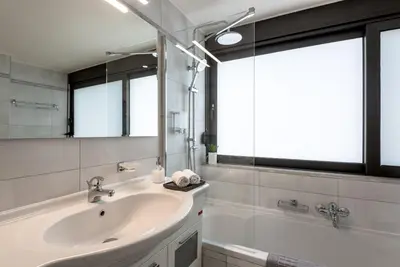 a bathroom with a sink and a tub and a mirror at Efrossini Suites in Kounoupidhianá