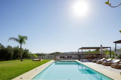 a swimming pool with lounge chairs and a resort at Quiet Villa Aviana,garden, heated pool,BBQ,jacuzzi in Gerani Chanion