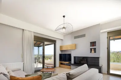 a living room with a couch and a tv at Quiet Villa Aviana,garden, heated pool,BBQ,jacuzzi in Gerani Chanion