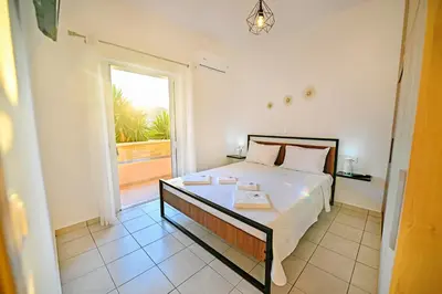 a bedroom with a bed and a large window at Artemis No1 Apartment in Kissamos