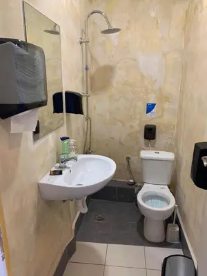 a bathroom with a sink and a toilet and a tv at Hippie City Hostel in Chania Town