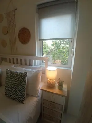 a bedroom with a bed with a lamp and a window at Kaldora Apartment in Chania Town