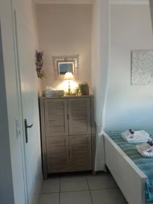 a small room with a bed and a lamp on a cabinet at Kaldora Apartment in Chania Town