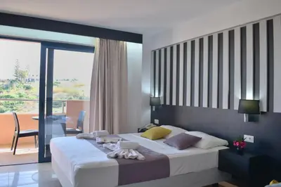 a bedroom with a large bed and a balcony at Galini Sea View Hotel in Agia Marina Nea Kydonias