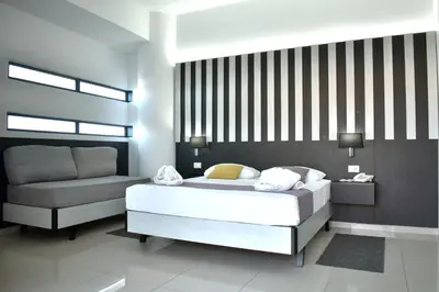 a bedroom with a white bed and a couch at Galini Sea View Hotel in Agia Marina Nea Kydonias