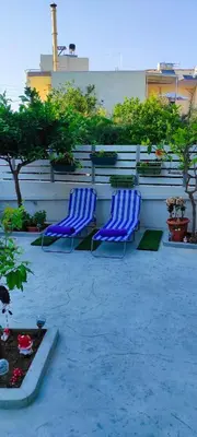 two blue chairs sitting on a patio next to a wall at Shiny Luxe :) in Kissamos