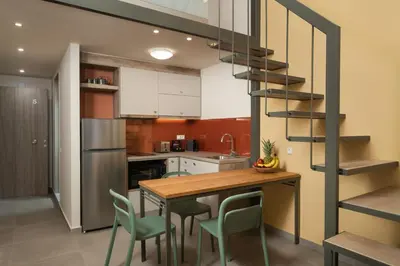a kitchen with a wooden table and green chairs at Dimitra Central Apts in Chania Town