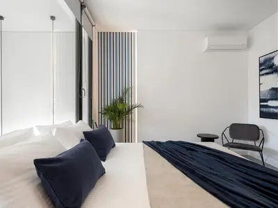 a bedroom with a large white bed with blue pillows at JnV Luxury Villas in Chania Town