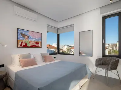 a white bedroom with a large bed and windows at JnV Luxury Villas in Chania Town
