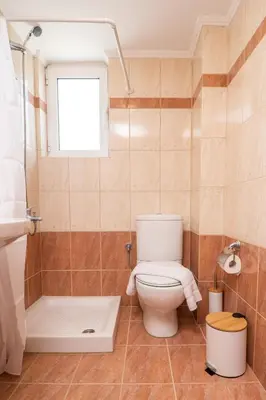 a bathroom with a toilet and a tub and a window at Ammoutsiani Cozy Apartment 1 by 8essentially in Chania Town