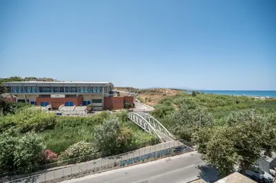 a building on a hill next to the ocean at Ammoutsiani Cozy Apartment 1 by 8essentially in Chania Town