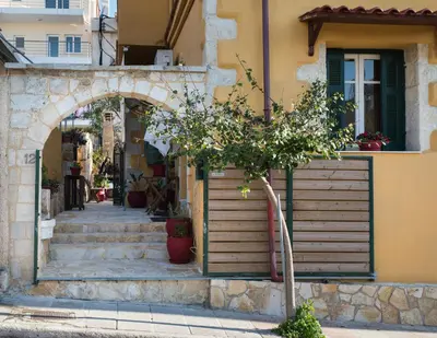 a tree in front of a building with an arch at Dominic Chania 3 Room Apartment in Chania Town