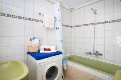 a bathroom with a washing machine and a tub at Dominic Chania 3 Room Apartment in Chania Town