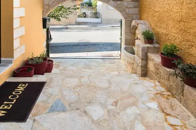 an entrance to a building with potted plants on the sidewalk at Dominic Chania 3 Room Apartment in Chania Town