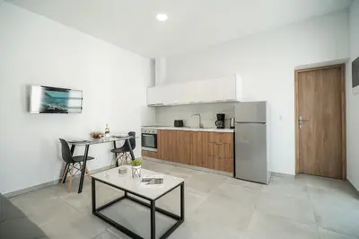 a kitchen with a table and a refrigerator at Kiani Apts in Kalyves