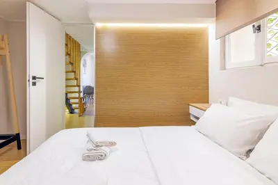 a white bed with a pair of handcuffs on it at Stef&Art Old Town House in Chania Town